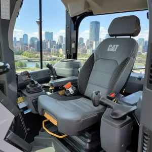 Highly detailed interior of a CAT heavy equipment cab, showing the clean seat and controls with the Calgary skyline in the background.